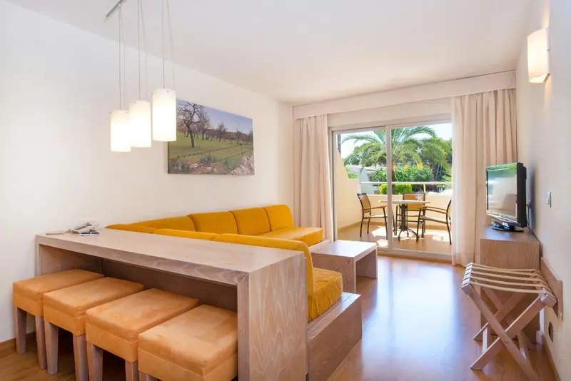 Espace de vie lumineux avec canapé jaune et table basse.