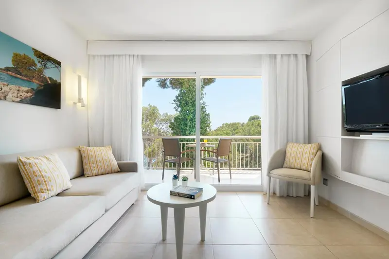 Espace de détente lumineux avec canapé et accès à une terrasse.