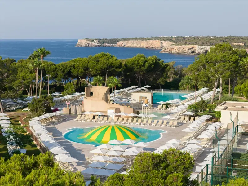Vue aérienne d'une piscine avec transats et parasols au bord de la mer.