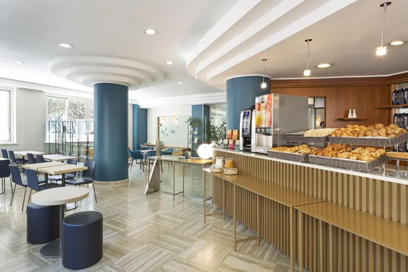 Une salle lumineuse avec un comptoir de buffet et des tables à manger.