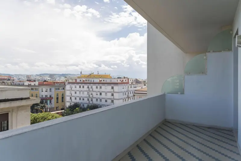 Balcon avec vue sur la ville et la mer.