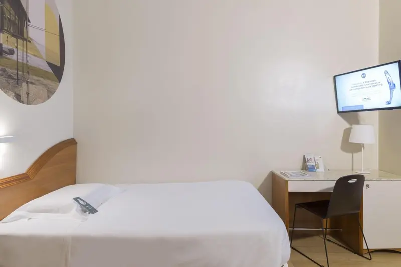 Une chambre lumineuse avec un lit simple et un bureau.