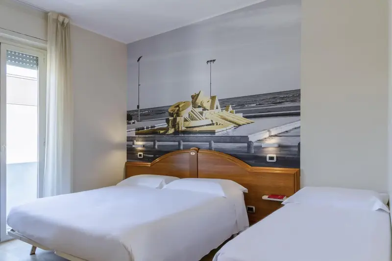 Une chambre avec un grand lit et une décoration murale représentant une scène marine.