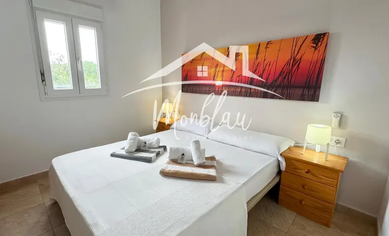 Une chambre lumineuse avec un grand lit et une décoration murale abstraite.