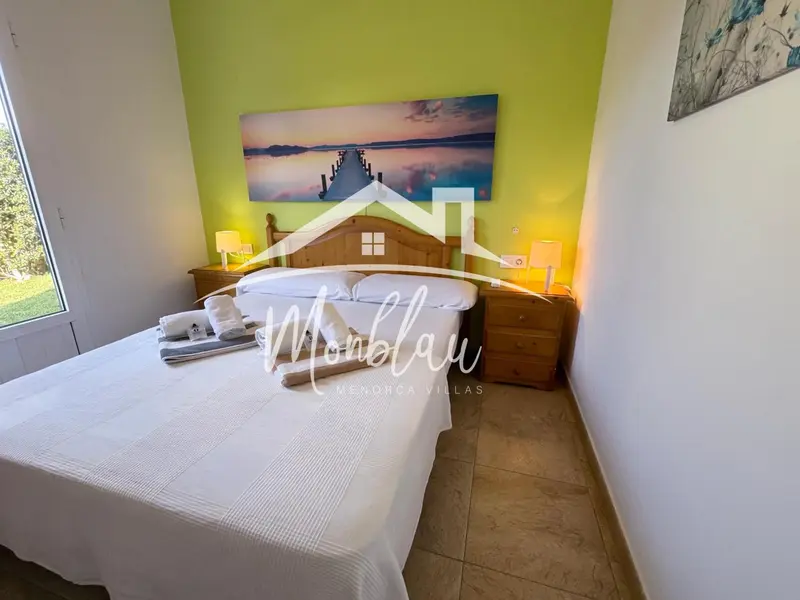 Une chambre lumineuse avec un grand lit et des tables de chevet.