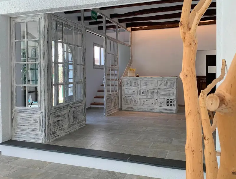 Un comptoir d'accueil en bois blanchi dans un espace lumineux et ouvert.