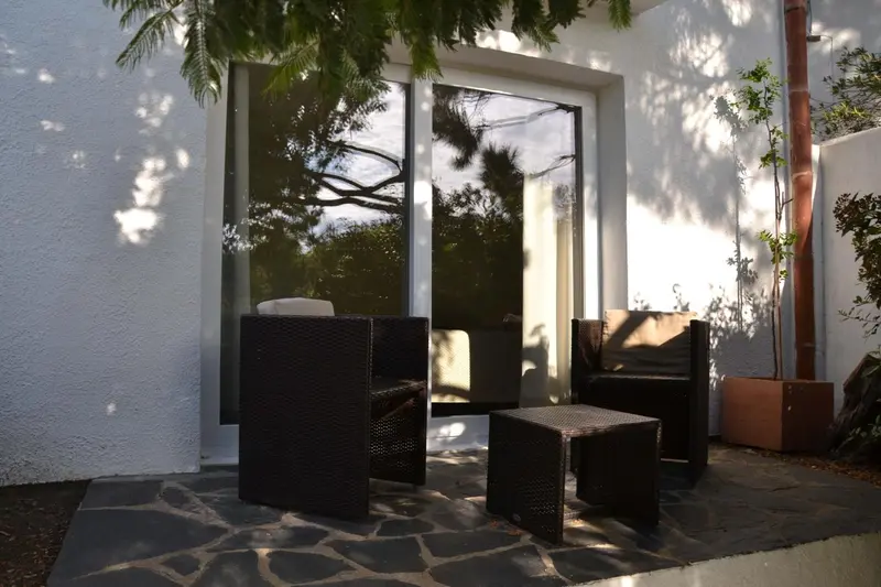 Mobilier de jardin sur une terrasse pavée.