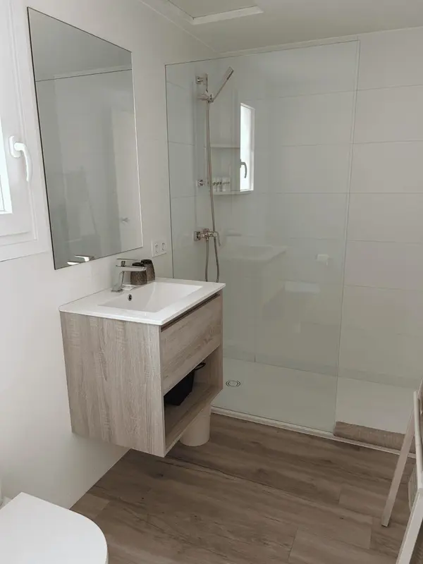 Une salle de bain moderne avec douche à l'italienne et meuble vasque.