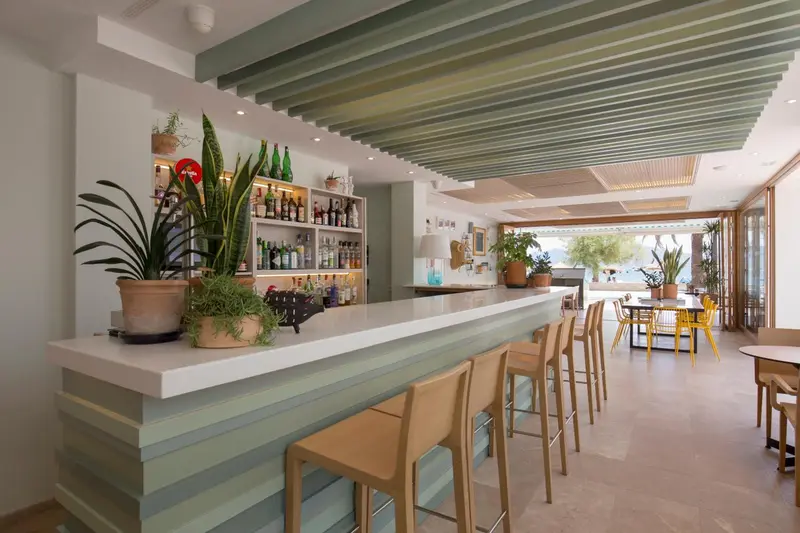 Un comptoir de bar moderne avec des tabourets et des étagères de boissons.