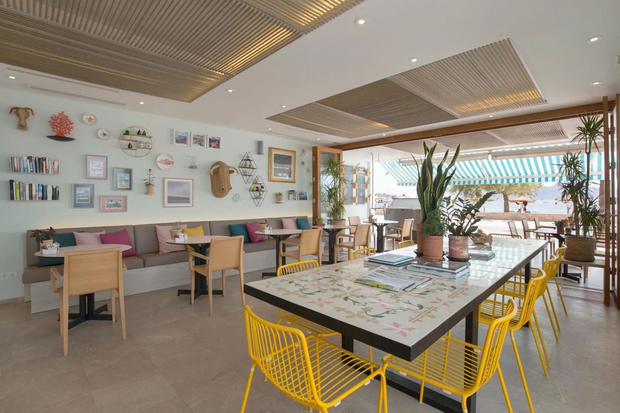 Une salle à manger lumineuse avec des tables et des chaises colorées.