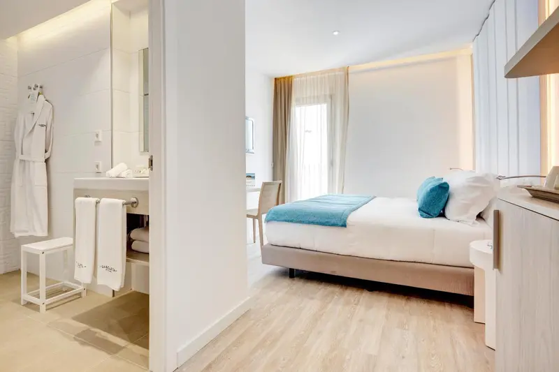 Une chambre lumineuse avec un lit et un espace salle de bain.