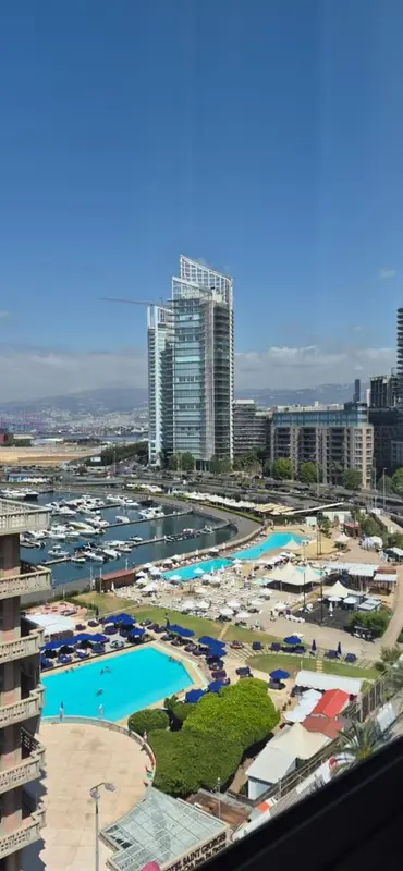 Vue aérienne sur un complexe hôtelier avec piscines et marina.