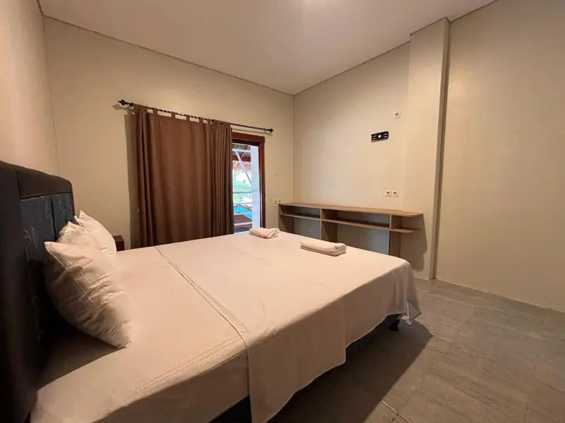 Une chambre lumineuse avec un grand lit et un bureau.