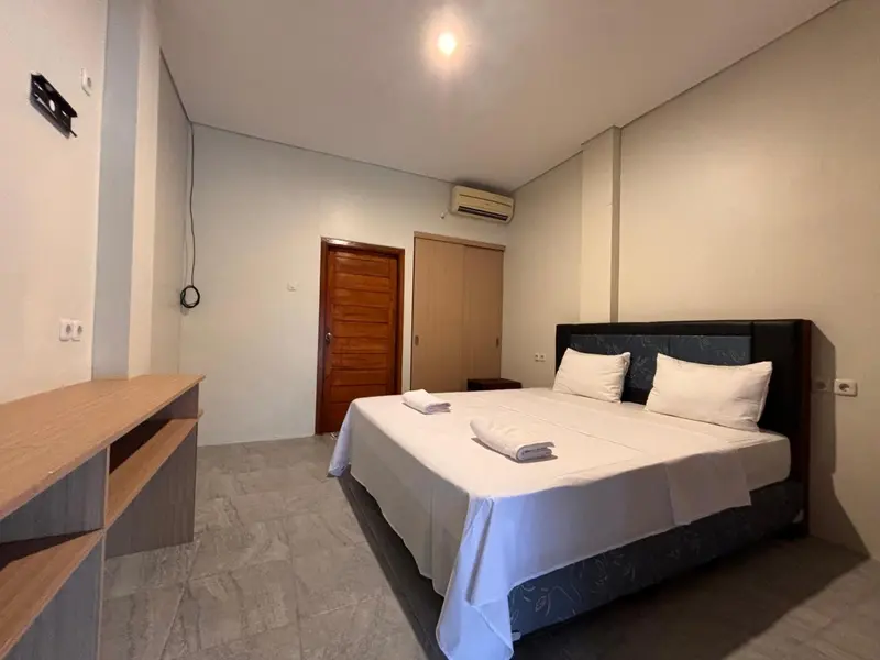 Une chambre lumineuse avec un grand lit et un bureau.