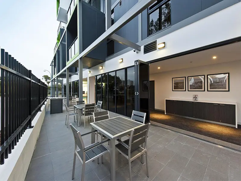 Terrasse aménagée avec tables et chaises devant une façade moderne.