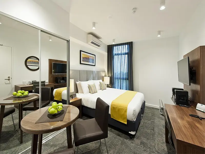Une chambre moderne avec un lit double et un coin repas.