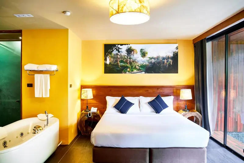 Une chambre lumineuse avec un grand lit et une baignoire à remous.