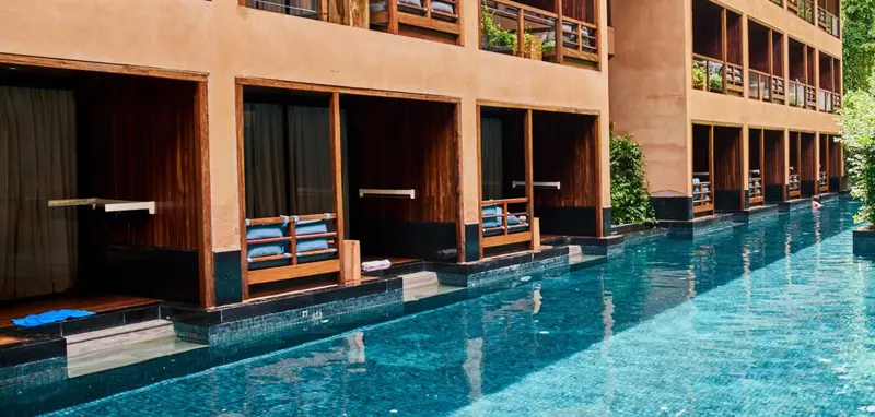 Balcons privés donnant sur une piscine turquoise.