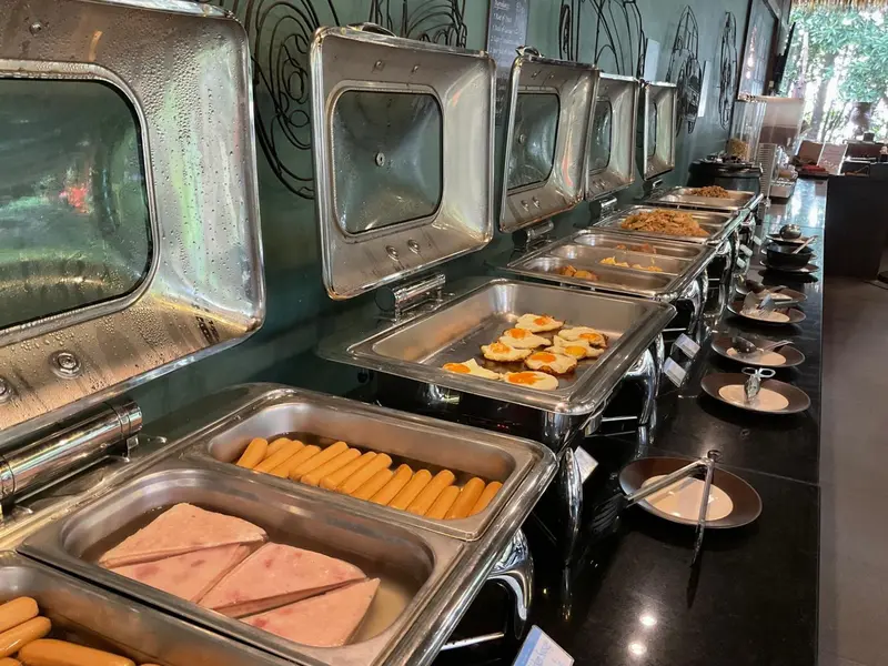 Un buffet propose une variété de plats chauds et de viennoiseries.