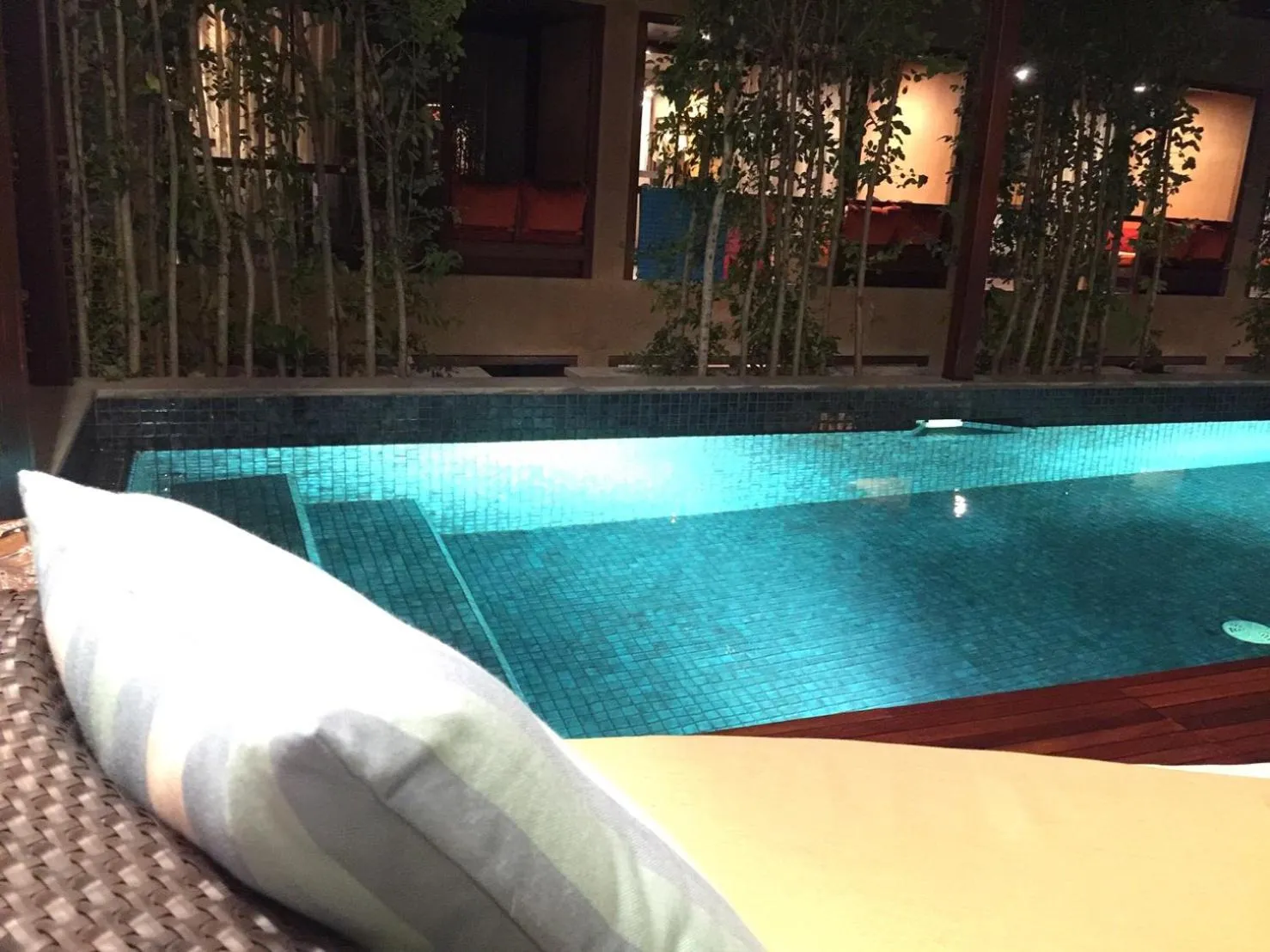 Une piscine rectangulaire avec des marches et une terrasse aménagée de transats.