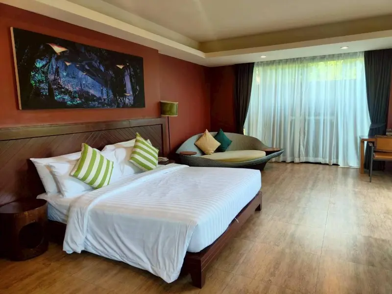 Une chambre lumineuse avec un grand lit et un espace détente.