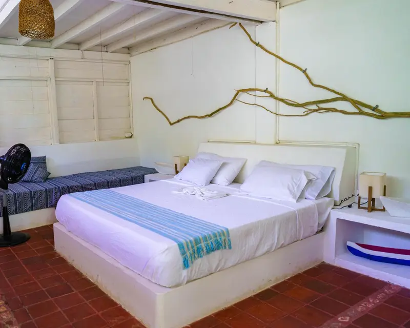 Une chambre lumineuse avec un lit recouvert d'un couvre-lit bleu et blanc.
