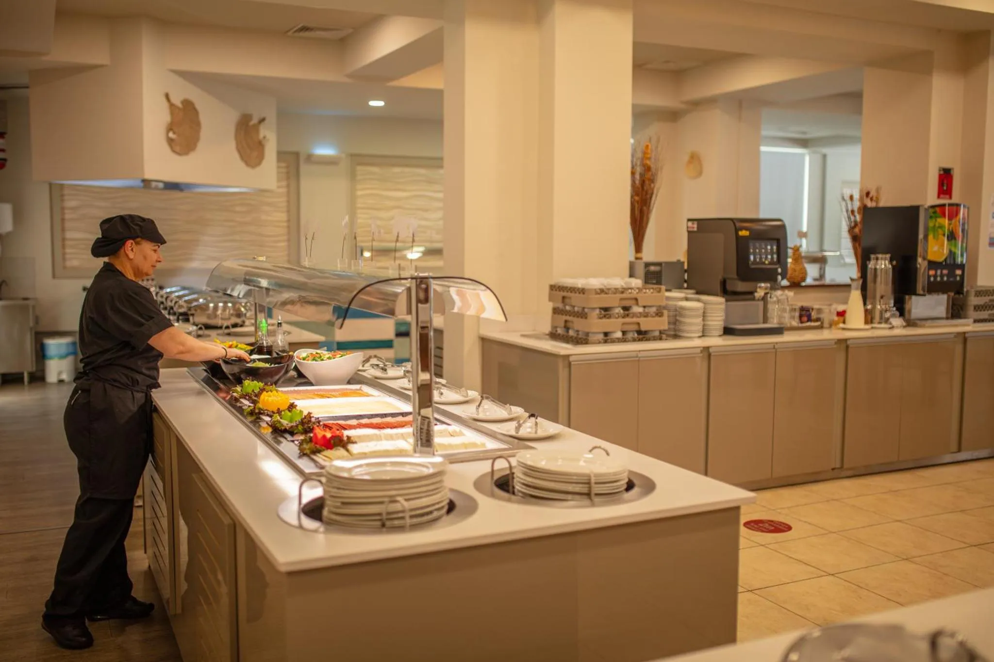 Un buffet propose une variété de plats frais et colorés dans un espace lumineux.