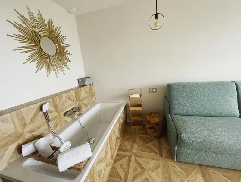 Une baignoire avec des serviettes et un miroir décoratif dans une salle de bain.