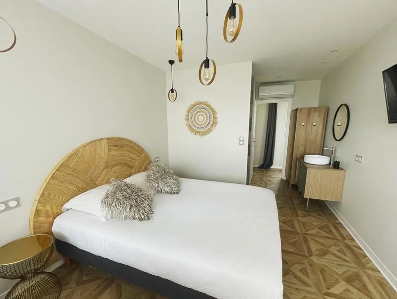 Une chambre lumineuse avec un grand lit et une décoration murale.