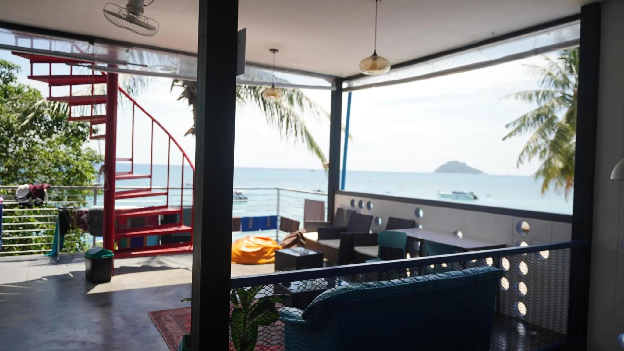 Espace de détente intérieur avec canapés bleus et vue sur la mer.