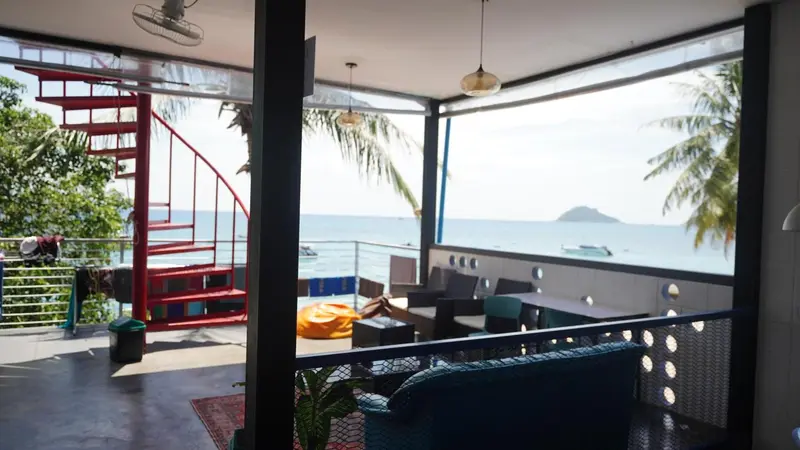 Espace de détente intérieur avec canapés bleus et vue sur la mer.