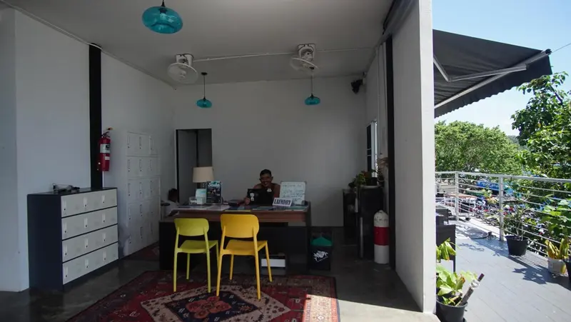 Un comptoir d'accueil avec deux chaises et des casiers dans un espace lumineux.