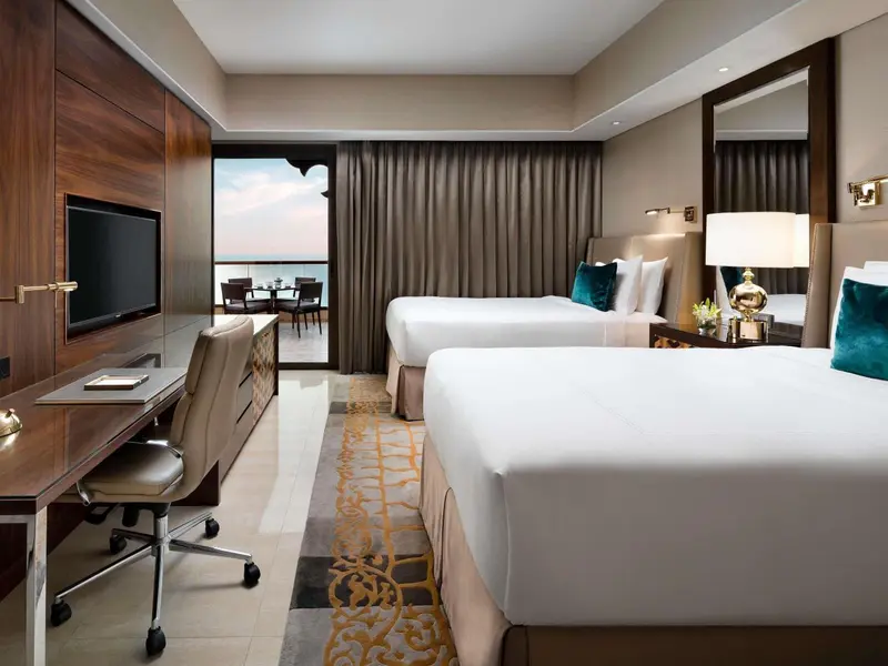 Chambre d'hôtel avec deux lits et accès à un balcon.