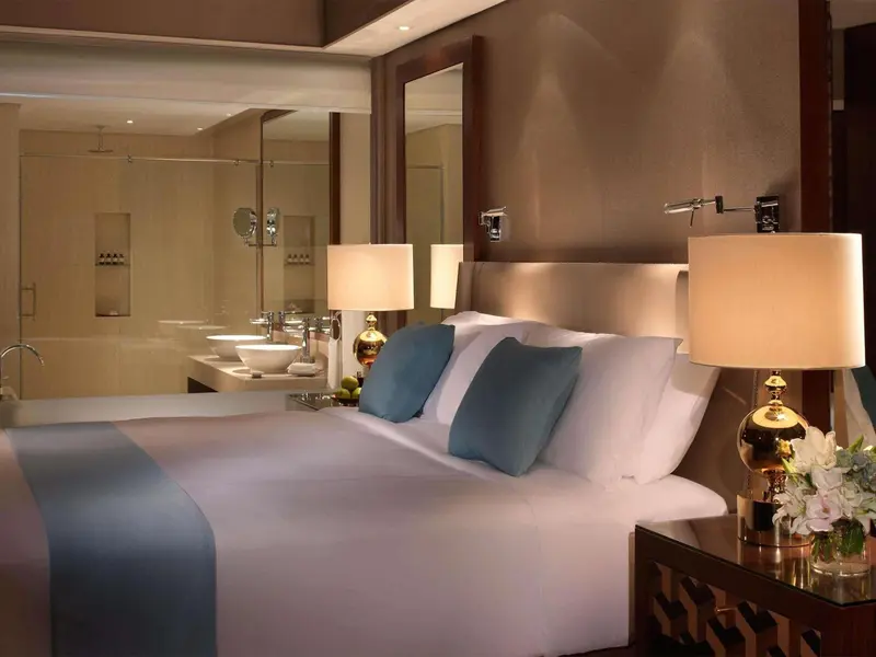 Une chambre lumineuse avec un grand lit et un espace salle de bain attenant.