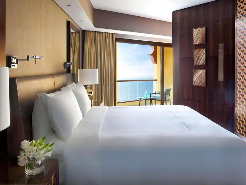 Une chambre lumineuse avec un grand lit et une vue sur la mer.