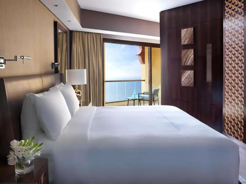 Une chambre lumineuse avec un grand lit donnant sur la mer.