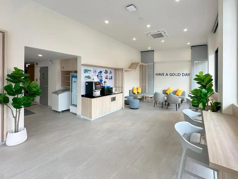 Espace d'accueil lumineux avec comptoir et assises confortables.