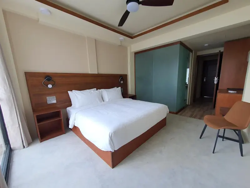 Une chambre lumineuse avec un grand lit et un espace détente.