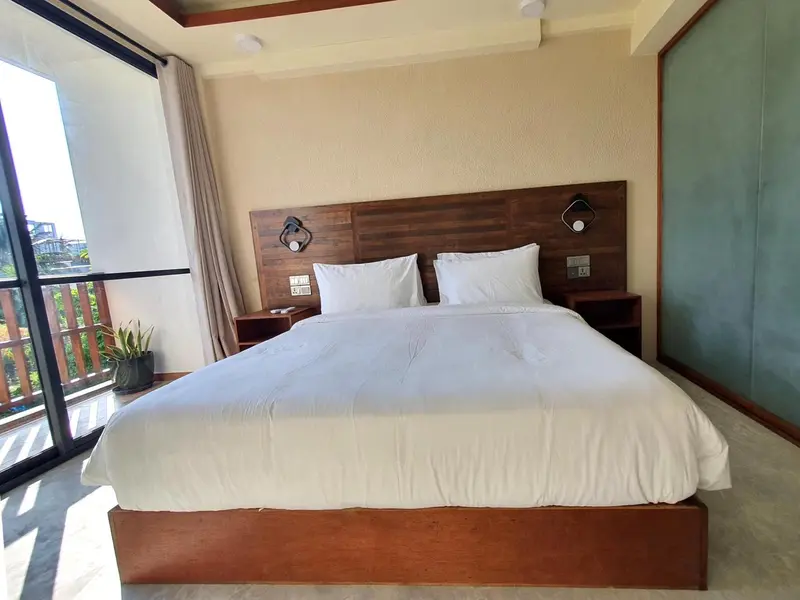 Une chambre lumineuse avec un grand lit recouvert de draps blancs.