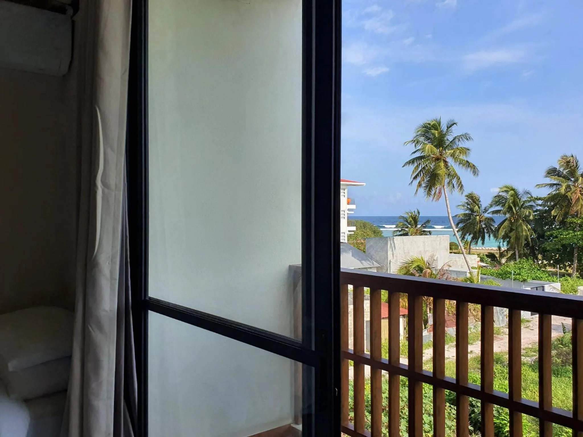 Vue sur la mer depuis une terrasse avec garde-corps en bois.