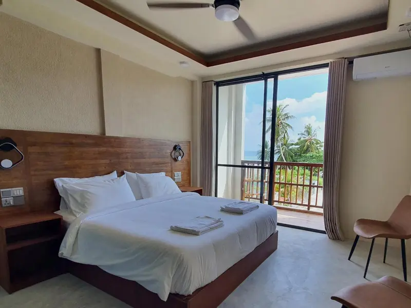 Une chambre lumineuse avec un grand lit et une vue sur la mer.
