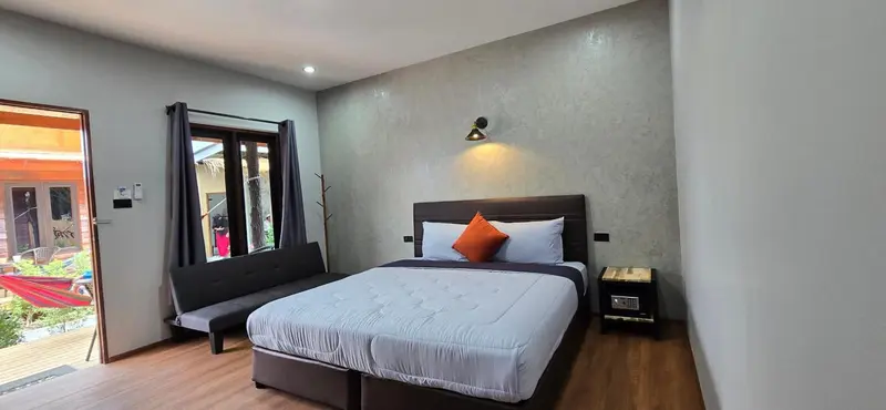 Une chambre avec un grand lit et un coin salon.