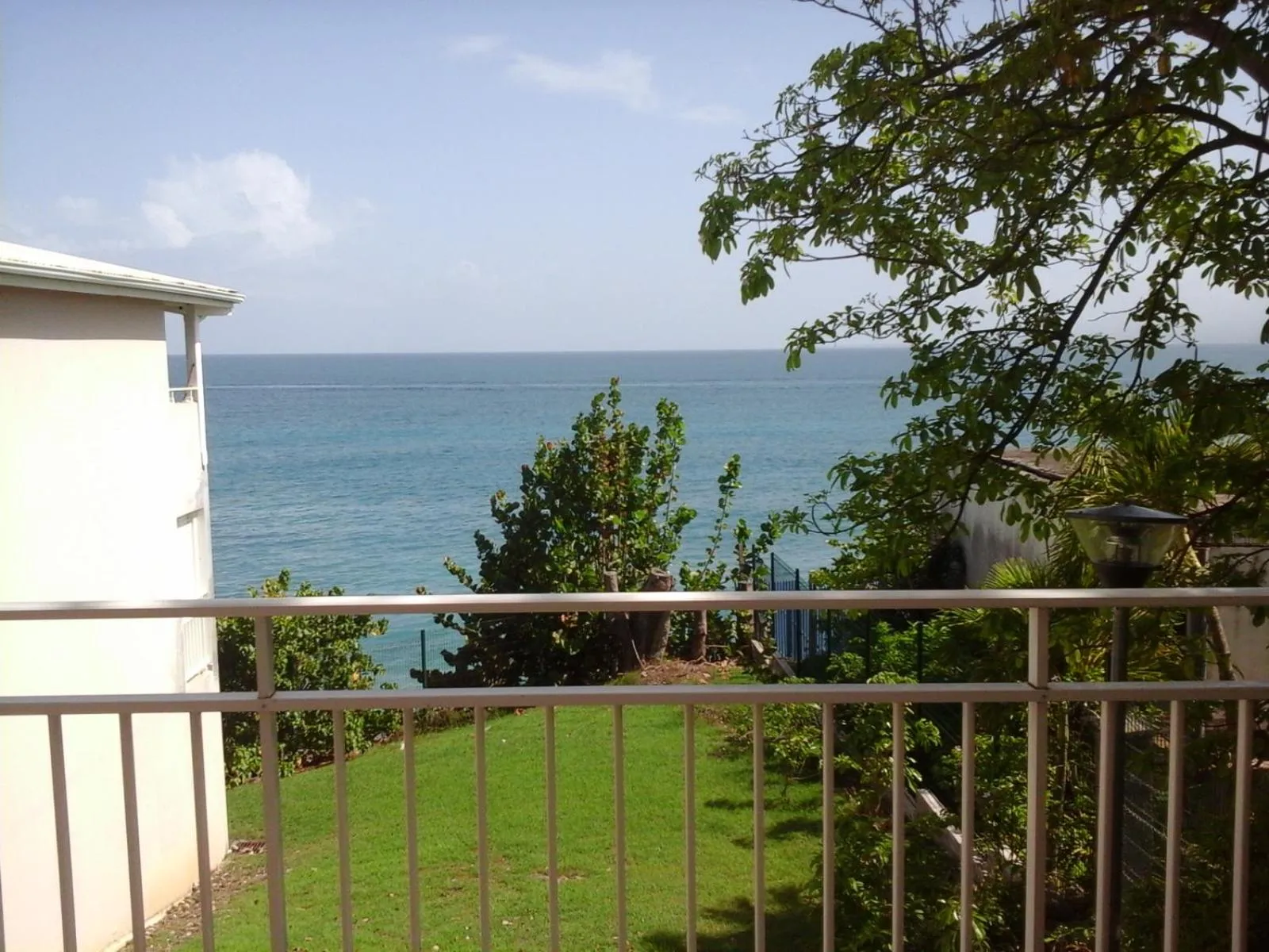Vue sur la mer depuis une terrasse ensoleillée.