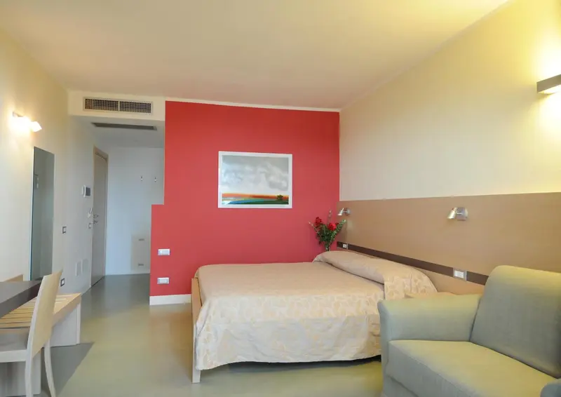 Une chambre lumineuse avec un canapé et un lit double.