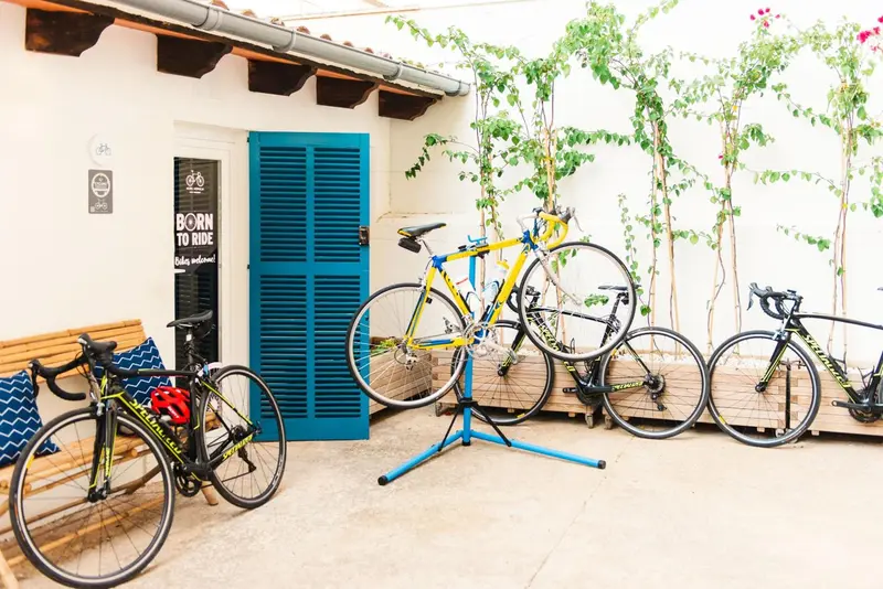 Des vélos sont rangés devant une porte bleue ornée de volets.