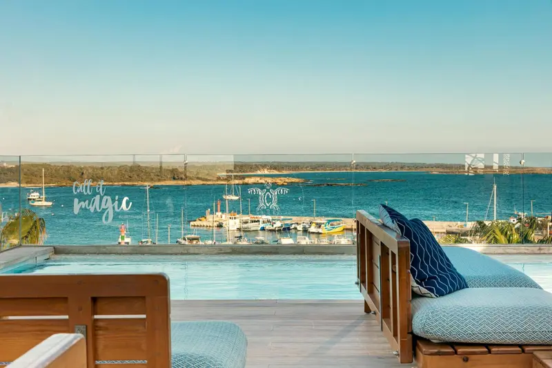 Terrasse avec piscine et vue sur un port de plaisance.