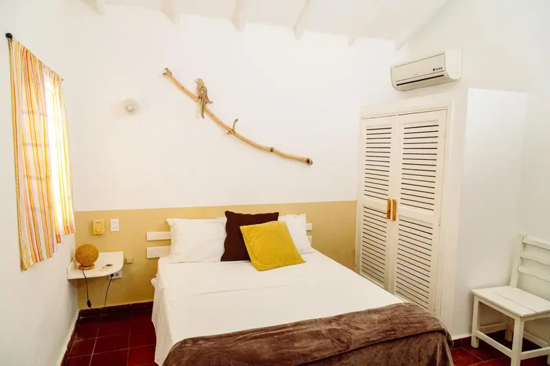 Une chambre lumineuse avec un lit simple et une décoration murale.