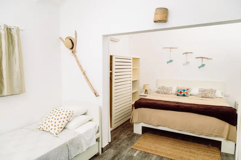 Une chambre lumineuse avec un lit double et un lit simple.