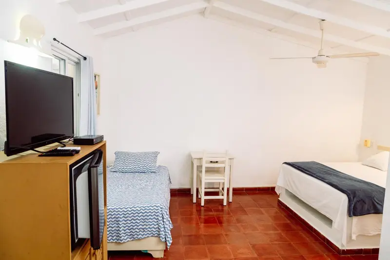 Une chambre lumineuse avec un lit simple et un lit double.