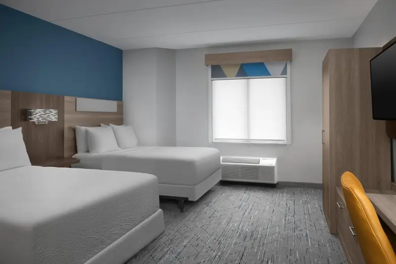 Une chambre d'hôtel avec deux lits et un bureau.